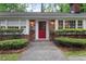 Inviting brick home entrance with a vibrant red front door and manicured shrubbery at 302 Chinquapin Sw Dr, Marietta, GA 30064