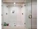 Large shower with white subway tile, glass door, and black and white tile floor at 302 Chinquapin Sw Dr, Marietta, GA 30064