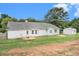 Green backyard with a patio area, detached storage shed and mature trees at 75 Plantation Ln, Locust Grove, GA 30248