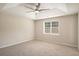 Spacious bedroom featuring a tray ceiling with a modern ceiling fan and a large window for ample natural light at 75 Plantation Ln, Locust Grove, GA 30248