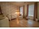 A cozy Bedroom featuring a crib, changing table, and accent wallpaper at 1122 Rice Nw St, Atlanta, GA 30318