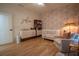 Warm Bedroom with crib, changing table, accent chair and rose patterned wallpaper at 1122 Rice Nw St, Atlanta, GA 30318