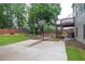 Backyard features concrete patio, lush green lawn, mature trees, and a basketball hoop at 1547 Trilogy Park, Hoschton, GA 30548