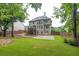 Spacious backyard with lush green lawn, trees, patio, and privacy fence at 1547 Trilogy Park, Hoschton, GA 30548
