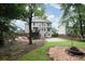 Large backyard featuring grassy area, mature trees, privacy fence, fire pit, and basketball court at 1547 Trilogy Park, Hoschton, GA 30548