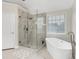 Bright bathroom featuring a soaking tub and a glass enclosed shower at 1547 Trilogy Park, Hoschton, GA 30548