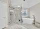Bathroom featuring a walk-in glass shower and soaking tub at 1547 Trilogy Park, Hoschton, GA 30548