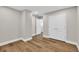 Neutral bedroom featuring hardwood floors, white trim, and a double closet at 1547 Trilogy Park, Hoschton, GA 30548