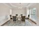 Elegant dining room with a chandelier, hardwood floors, and wainscoting, perfect for entertaining at 1547 Trilogy Park, Hoschton, GA 30548