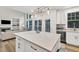 Kitchen with white island, stainless appliances, and view to living area at 1547 Trilogy Park, Hoschton, GA 30548