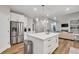 Kitchen with stainless steel appliances, island, and view to living room at 1547 Trilogy Park, Hoschton, GA 30548