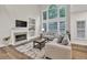 Bright living room with large windows, fireplace, and neutral decor at 1547 Trilogy Park, Hoschton, GA 30548