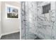 Modern bathroom featuring a glass shower with decorative tile and a bright window at 2178 Shamrock Dr, Decatur, GA 30032