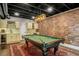 Finished basement with a brick accent wall, pool table, and a kitchenette at 2573 Paul Nw Ave, Atlanta, GA 30318