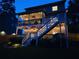 Rear view of a house featuring a screened in porch decorated with outdoor lights at dusk at 2573 Paul Nw Ave, Atlanta, GA 30318