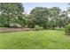 Expansive backyard with a low brick wall and mature trees at 2644 Hickory Valley Dr, Snellville, GA 30078