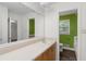 Bathroom features a white vanity with a long mirror and doorway leading to lime green-painted water closet at 2644 Hickory Valley Dr, Snellville, GA 30078