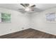 Well-lit bedroom with hardwood floors, neutral paint, ceiling fan, and windows with exterior views at 2644 Hickory Valley Dr, Snellville, GA 30078
