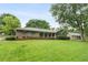 Charming brick home featuring a large front yard with mature trees and manicured shrubs at 2644 Hickory Valley Dr, Snellville, GA 30078