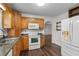 Well-lit kitchen features white appliances, tile backsplash, stainless steel sink, and oak cabinets at 2644 Hickory Valley Dr, Snellville, GA 30078