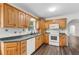 Galley kitchen includes oak cabinets, updated appliances, granite counters, and hardwood floors at 2644 Hickory Valley Dr, Snellville, GA 30078