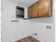 Laundry room with upper and lower cabinets, washer and dryer hookups, and hardwood flooring at 2644 Hickory Valley Dr, Snellville, GA 30078