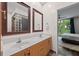 Bathroom boasting double sinks with wooden cabinetry and large mirrors, with view to bedroom at 1308 Fernwood Ne Cir, Atlanta, GA 30319