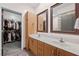 Bathroom boasting double sinks with wooden cabinetry, large mirrors, and a walk-in closet at 1308 Fernwood Ne Cir, Atlanta, GA 30319