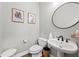 This elegant half bathroom features a pedestal sink with stylish fixtures and is decorated with botanical themed art at 1308 Fernwood Ne Cir, Atlanta, GA 30319