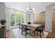 Bright dining room boasts a modern light fixture, minimalist decor, exposed brick and large windows at 1308 Fernwood Ne Cir, Atlanta, GA 30319