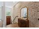 Inviting entryway featuring wood floors, exposed brick, cabinet with a decorative mirror creating an elegant ambiance at 1308 Fernwood Ne Cir, Atlanta, GA 30319