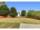 Grassy backyard surrounded by a wooden fence and mature trees offers privacy and space at 1942 Westover Nw Ln, Kennesaw, GA 30152