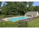 A view of the pool with chairs and tables surrounded by trees at 1942 Westover Nw Ln, Kennesaw, GA 30152