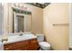 A traditional bathroom with wooden vanity, floral wallpaper, and a classic toilet at 2881 Bridle Creek Sw Dr, Conyers, GA 30094