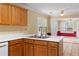 A kitchen featuring wooden cabinets and a stainless steel sink overlooking a bright and airy dining area at 2881 Bridle Creek Sw Dr, Conyers, GA 30094