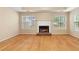 Inviting living room with hardwood floors and a brick fireplace, illuminated by natural light through large windows at 2881 Bridle Creek Sw Dr, Conyers, GA 30094