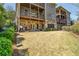 This grassy backyard has a covered patio with a grilling area and a view of the multi-story home at 4541 Gateway Se Ct, Smyrna, GA 30080