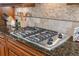 A kitchen with a stainless steel cooktop, granite countertops, and custom cabinets at 4541 Gateway Se Ct, Smyrna, GA 30080