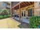 This outdoor patio features a stone facade, covered grilling area, recessed lighting, and a grassy backyard at 4541 Gateway Se Ct, Smyrna, GA 30080