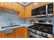 Compact kitchen featuring stainless steel appliances, wood cabinets, and a light blue backsplash at 2479 Peachtree Ne Rd # 305, Atlanta, GA 30305