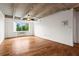 Living room featuring hardwood floors, an exposed concrete ceiling, and natural light from the large window at 2479 Peachtree Ne Rd # 305, Atlanta, GA 30305