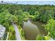 Tranquil pond surrounded by mature trees, lush green landscaping, and homes in the surrounding neighborhood at 2479 Peachtree Ne Rd # 305, Atlanta, GA 30305