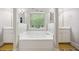 Bathroom features a soaking tub with double vanities and large window at 4608 Treasure Ct, Forest Park, GA 30297