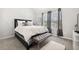 Stylish bedroom with geometric accent wall, plush bench, and ample natural light from the large window at 4608 Treasure Ct, Forest Park, GA 30297