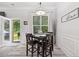 Dining area with views of the backyard, modern light fixture, and white wainscoting at 4608 Treasure Ct, Forest Park, GA 30297
