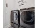 Well-equipped laundry room with modern black washer and dryer, plus cute 'Laundry' themed wall art at 4608 Treasure Ct, Forest Park, GA 30297
