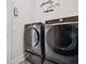 Laundry room with new washer and dryer on platforms, and decorated wall at 4608 Treasure Ct, Forest Park, GA 30297