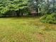Large backyard with mature trees, providing shade and privacy, and a partial fence at 4889 Fairforest Dr, Stone Mountain, GA 30088