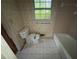 Bathroom featuring a toilet, tub/shower combo, tile flooring, and a window at 4889 Fairforest Dr, Stone Mountain, GA 30088