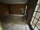 Living room features a brick fireplace, access to the exterior, wood paneling, and the floors need replacement at 4889 Fairforest Dr, Stone Mountain, GA 30088